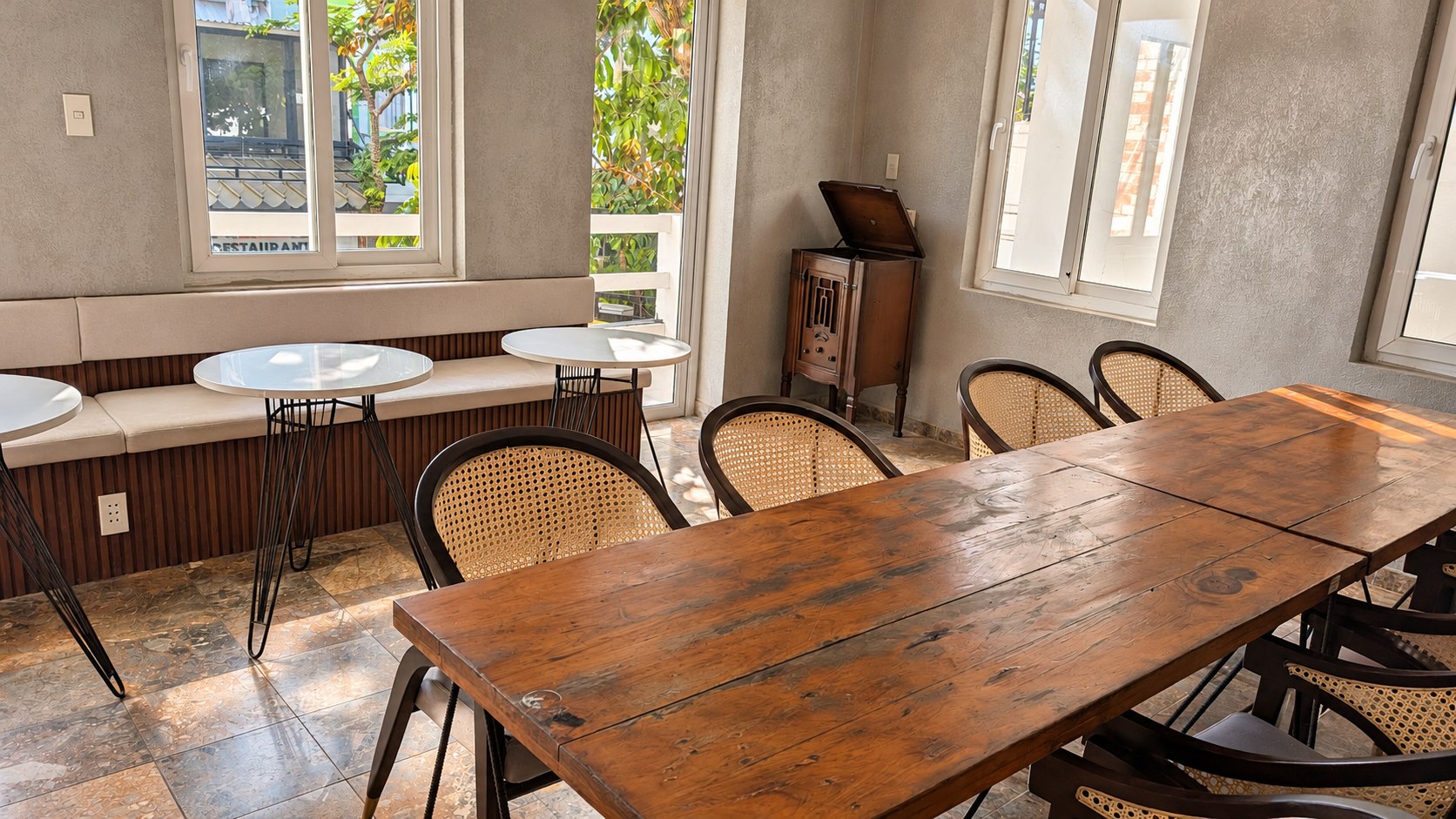 Long wooden table and cane chairs beside the front windows